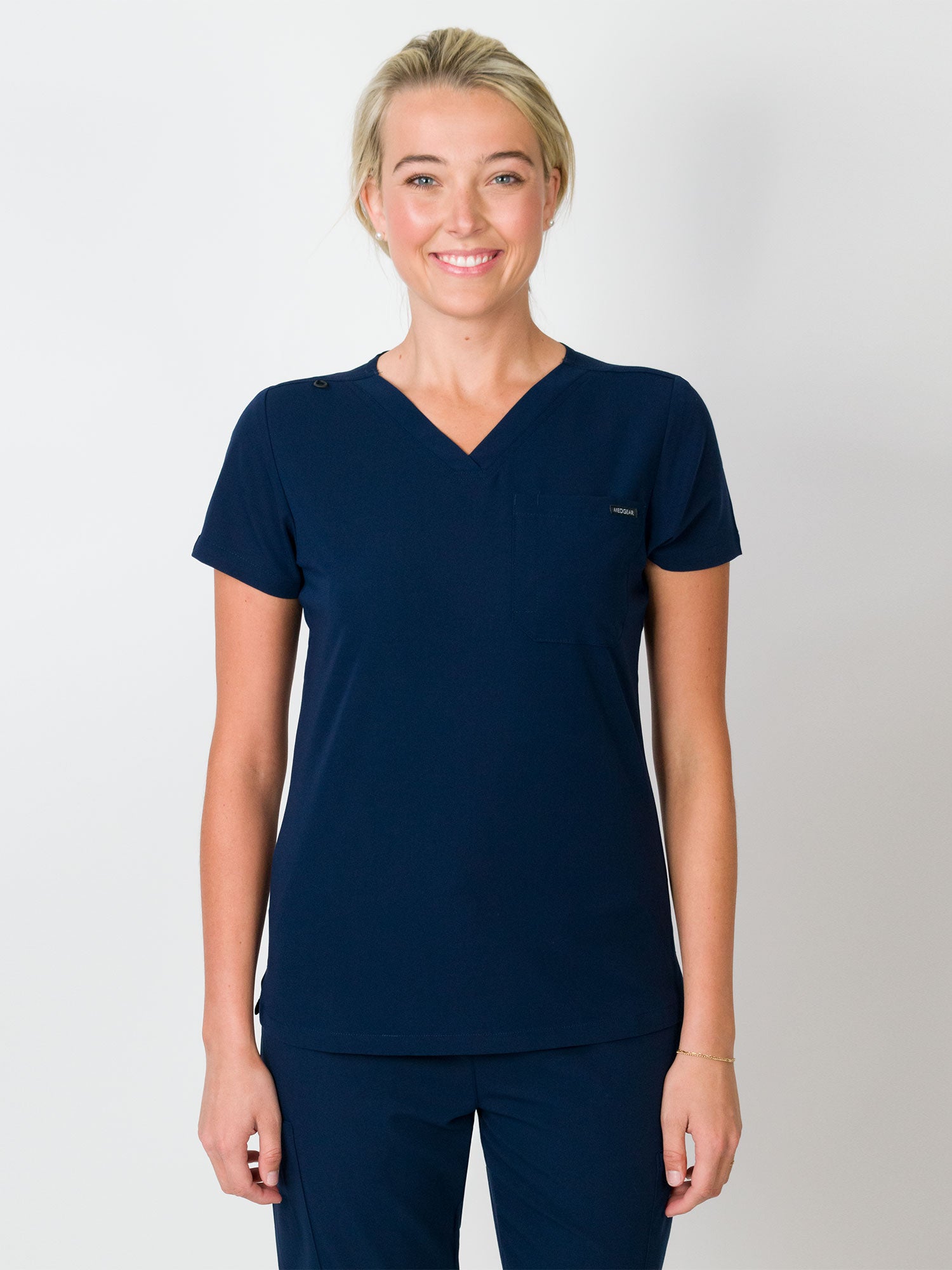 Navy-colored scrubs top with a single chest pocket and a V-neck, with Medgear branding.
