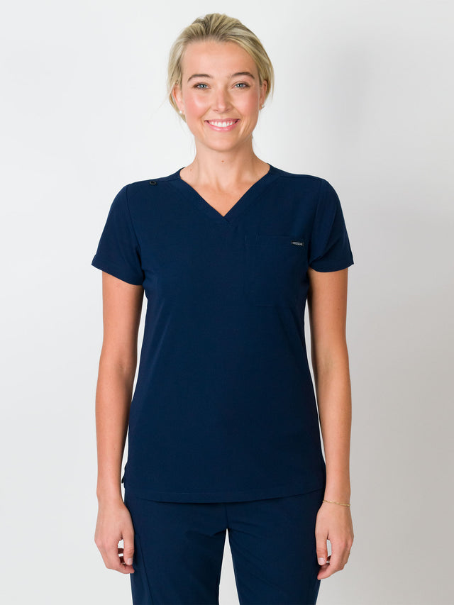 Navy-colored scrubs top with a single chest pocket and a V-neck, with Medgear branding.