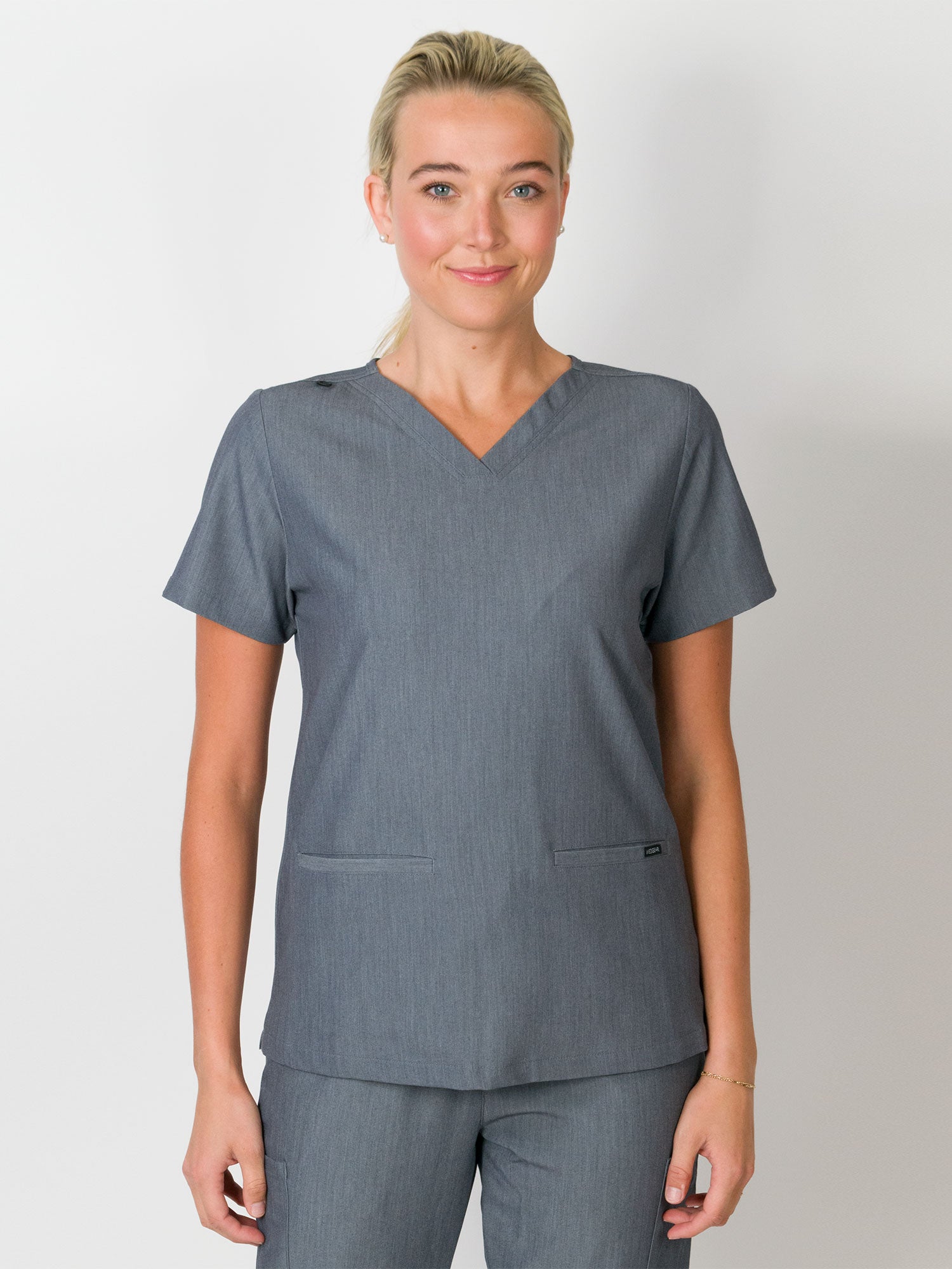 Gray V-neck Medgear scrubs top. Three-pocket top with a slim fit, made from MG-LUX fabric.