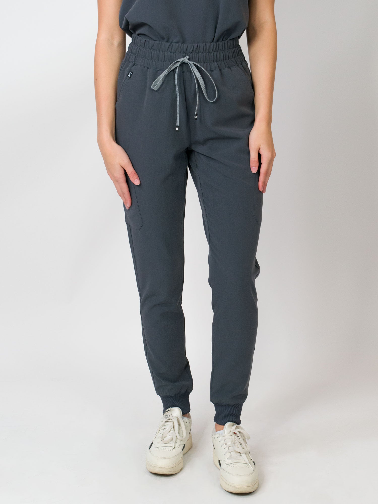 Gray mid-rise slim jogger scrub pants with Medgear branding, an elastic waistband and drawstring, with multiple pockets.