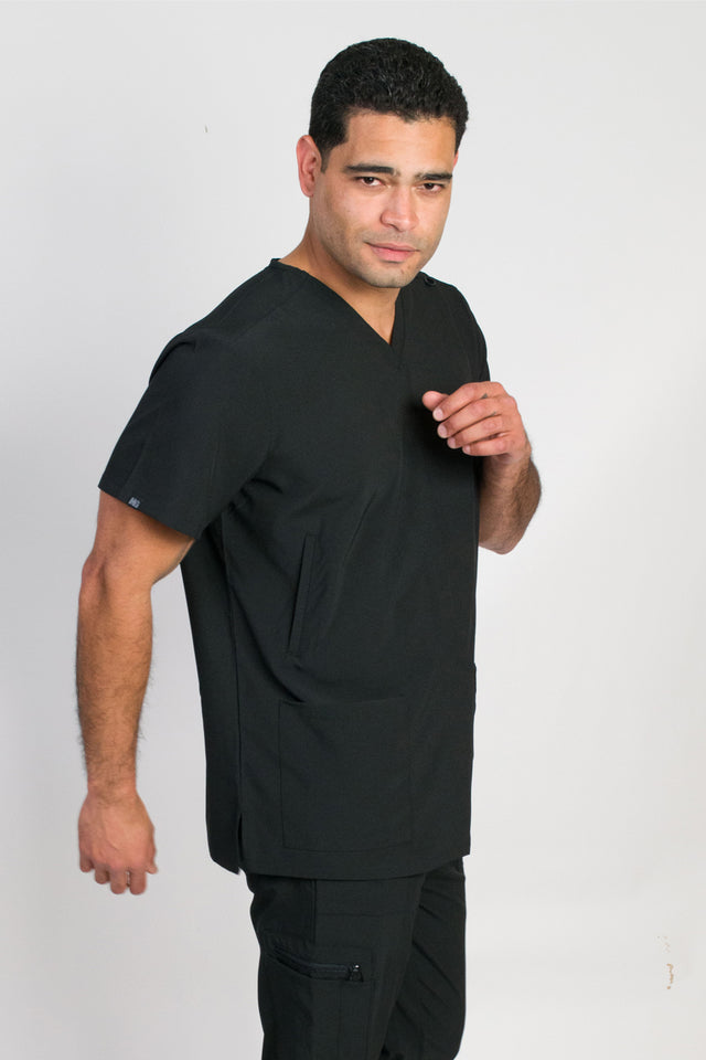 A male wearing a black scrubs top medical uniform with a classic V-neckline and 5 pockets, including handwarmers on the sides.