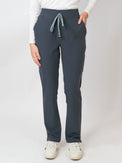 A woman wearing navy mid-rise slim straight scrub pants with an adjustable drawstring and multiple pockets, with Medgear branding.