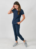 Woman modeling a women's medical scrub set with a V-neck top and jogger pants in navy blue color, featuring multiple pockets.
