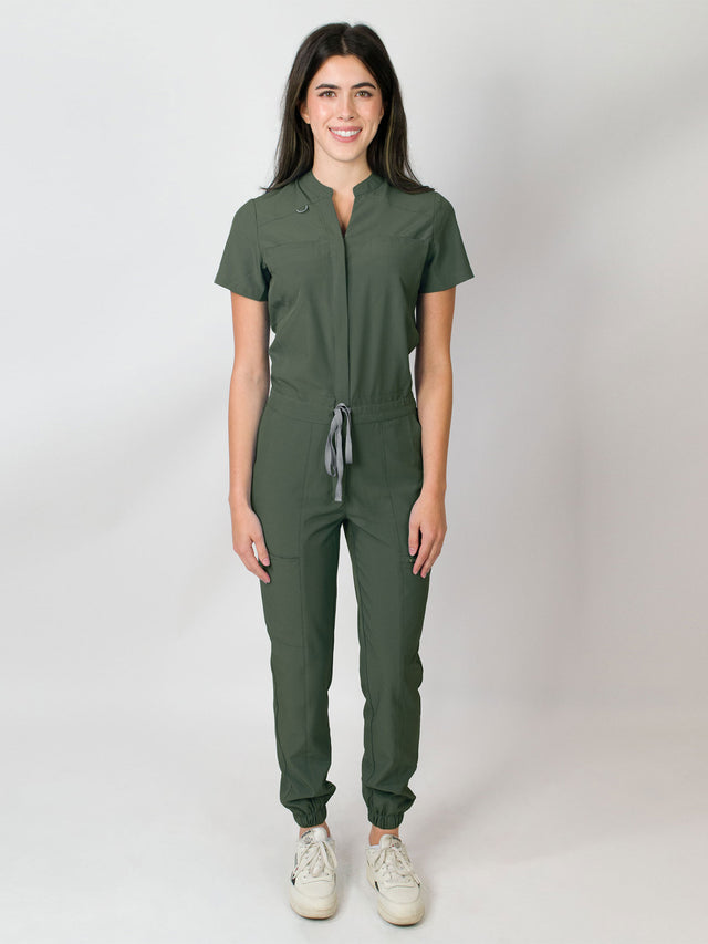 Seaweed green scrub jumpsuit with a mandarin collar, short sleeves, and elastic jogger cuffs. The jumpsuit has multiple pockets and a zipper front.